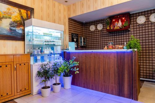eine Bar in einem Restaurant mit Uhren an der Wand in der Unterkunft Aqua Long Son Hotel in Ho-Chi-Minh-Stadt