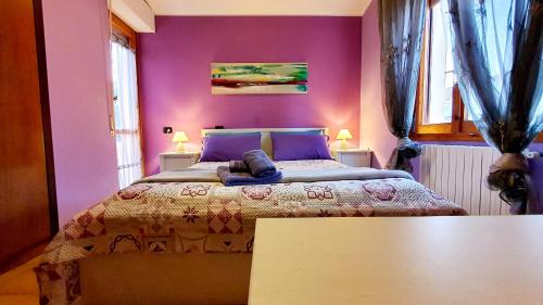 sypialnia z dużym łóżkiem i fioletowymi ścianami w obiekcie Casa Madda w mieście Selargius