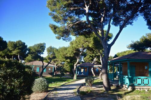 uma casa com uma árvore ao lado de uma estrada em Martigues, les Chalets de la Mer **** em Martigues