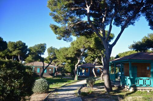 une maison avec un arbre à côté d'une route dans l'établissement Martigues, les Chalets de la Mer ****, à Martigues