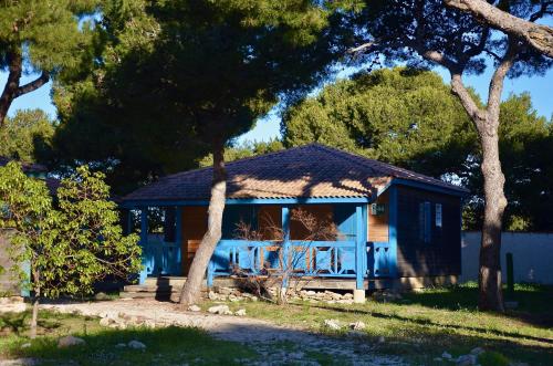 um barracão azul com um telhado num quintal em Martigues, les Chalets de la Mer **** em Martigues