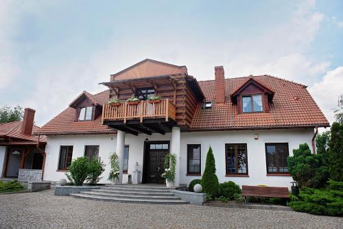 a house with a balcony on top of it at Hotel Ranczo Smyczyna in Smyczyna