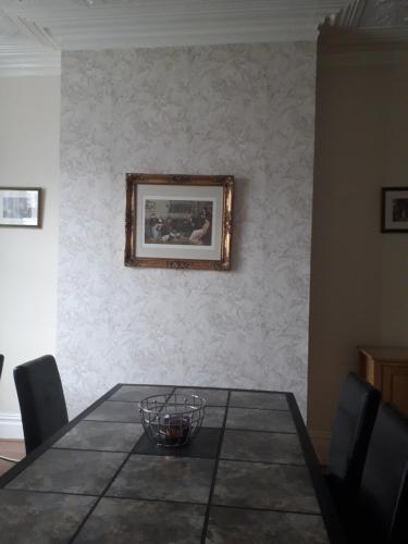 a dining room with a table and a picture on the wall at Witton house in Blackpool