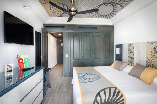 a bedroom with a bed and a ceiling fan at Hotel Riu Vistamar Gran Canaria - All Inclusive in Puerto Rico de Gran Canaria