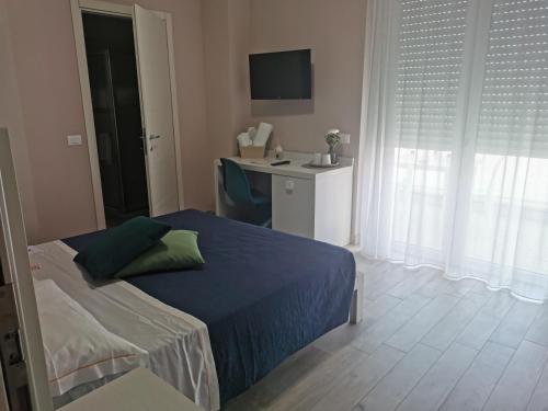 a bedroom with a bed and a desk with a monitor at Elite Boutique Hotel in Roseto degli Abruzzi