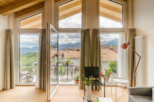 a living room with large windows and a view of the mountains at Orizzonti d'Anaunia in Tassullo