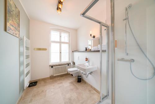 a bathroom with a shower and a toilet and a sink at Design Apartments - "Villa Arnim" in Potsdam