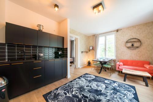 a kitchen with black cabinets and a red couch at Design Apartments - "Villa Arnim" in Potsdam