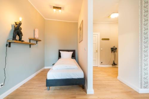 a small bedroom with a bed and a hallway at Design Apartments - "Villa Arnim" in Potsdam