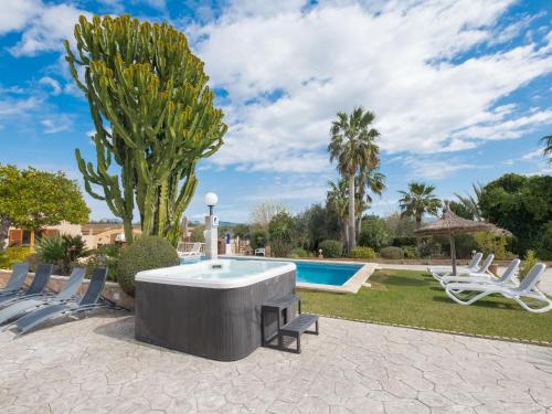 a pool with chairs and a hot tub in a yard at Holiday Home Ca Na Guerrera by Interhome in Crestatx