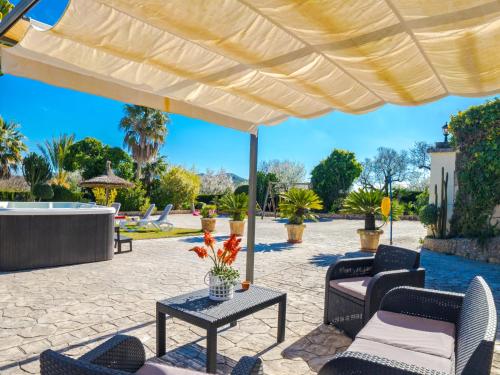 a patio with chairs and a large umbrella at Holiday Home Ca Na Guerrera by Interhome in Crestatx