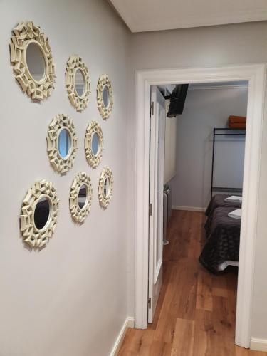 a hallway with gold framed mirrors on a wall at Pensión El Espolón in Logroño