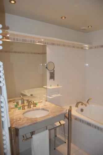 a bathroom with a sink and a tub at Absolue Renaissance in Magny-Cours