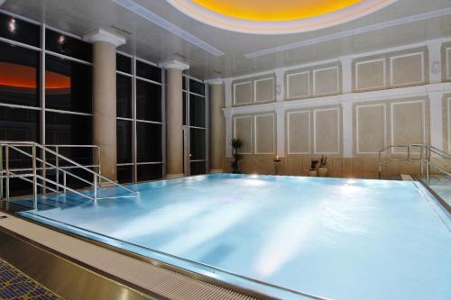 a large swimming pool in a room with a ceiling at Kúpele Brusno - Kúpeľný hotel Poľana in Brusno