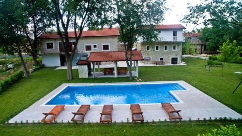 an overhead view of a swimming pool with chairs and a house at Stara kuća Estate in Ljubuški
