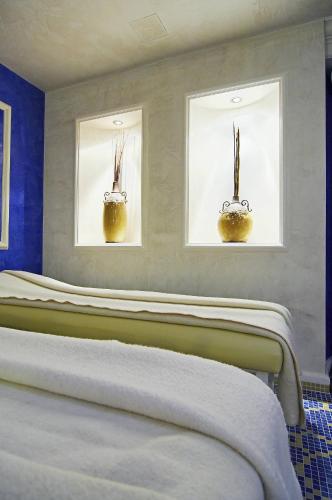 a row of beds in a room with two windows at Kúpele Brusno - Kúpeľný hotel Poľana in Brusno