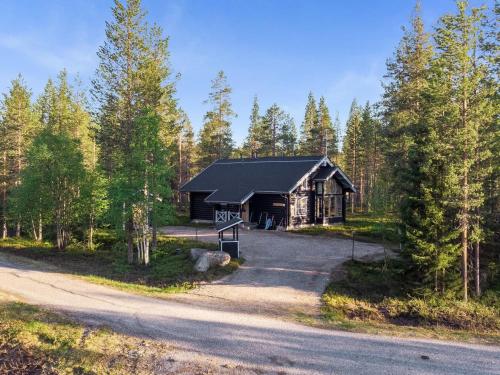 une cabane en rondins dans les bois à côté d'une route dans l'établissement Holiday Home Aspilevi by Interhome, à Levi