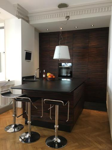 une cuisine avec un comptoir noir et deux tabourets de bar dans l'établissement Le PALAIS, Promenade des Anglais, Luxry app, 2 ch, 2 SDB, 88m, à Nice