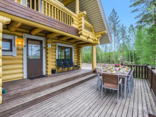 une terrasse en bois avec une table et des chaises sur une maison dans l'établissement Holiday Home Aurinkoranta by Interhome, à Halttula