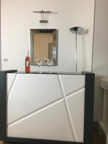 un miroir et deux verres à vin sur un comptoir dans l'établissement Le PALAIS, Promenade des Anglais, Luxry app, 2 ch, 2 SDB, 88m, à Nice