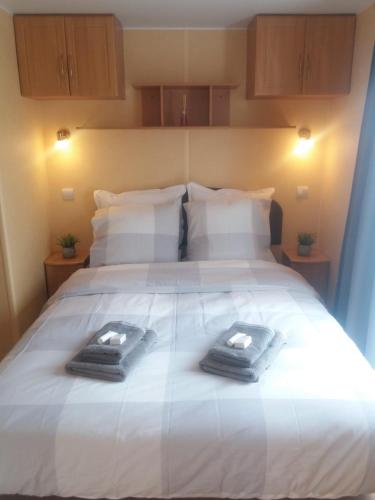a large white bed with two towels on it at Haerendycke Park in De Haan