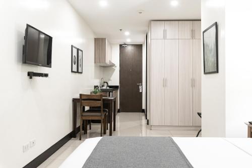 a bedroom with a bed and a dining room at Artemis Place Makati Hotel in Manila