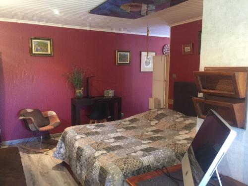 1 dormitorio con paredes rojas, 1 cama y escritorio en Le jardin de THELEME "Charme discret pour un nid douillet", en Mazille