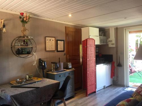 a kitchen with a table and a kitchen with a stove at Le jardin de THELEME "Charme discret pour un nid douillet" in Mazille