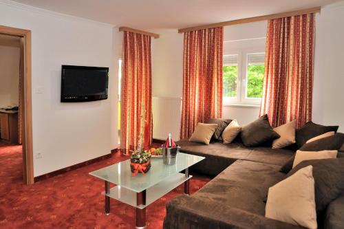 a living room filled with furniture and a tv at Hotel Medno in Ljubljana