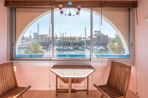 a window with two chairs and a table in front of it at locaportleucate in Leucate