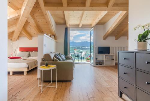 a living room with a bed and a couch at Orizzonti d'Anaunia in Tassullo