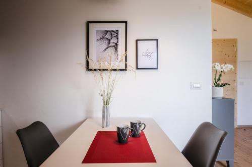 a dining room with a table with a red napkin at Orizzonti d'Anaunia in Tassullo