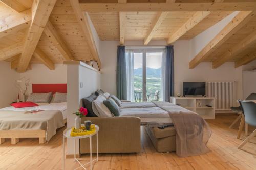 a bedroom with two beds and a couch and a tv at Orizzonti d'Anaunia in Tassullo