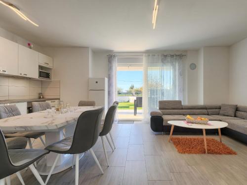 eine Küche und ein Wohnzimmer mit einem Tisch und einem Sofa in der Unterkunft Holiday Home Villa Zirdum by Interhome in Nova Vas