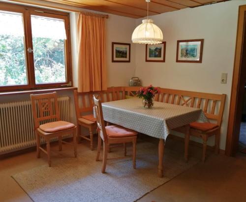 een eettafel en stoelen met een tafel en een tafel en een tafel bij Ferienwohnung Waldhaus in Sankt Gallenkirch