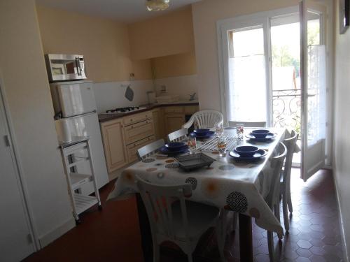 eine Küche mit einem Tisch und einem weißen Tischtuch in der Unterkunft Appartement Vallée de Luchon in Salles-et-Pratviel
