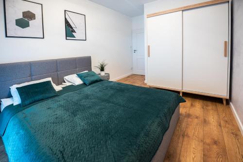 1 dormitorio con 1 cama grande con manta verde en Marina Lake Iława, en Iława