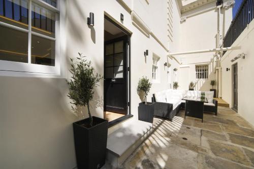 a patio with potted plants on the side of a building at Newly Refurbished Flat With Patio. By Hyde Park in London