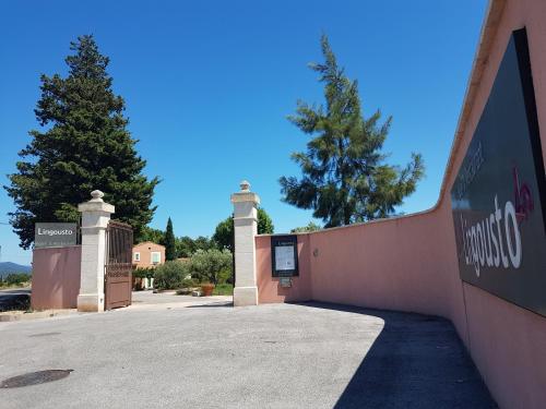 a gate to a building with a sign on it at Le Mas du Lingousto in Cuers