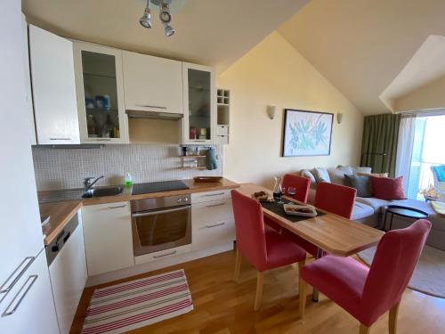 a kitchen and living room with a table and red chairs at Werz Sea View Apartment in Brela