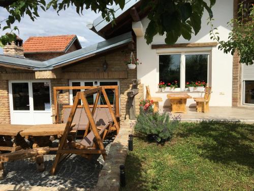 a backyard with a wooden bench and a house at Matanovi Dvori in Slavonski Brod
