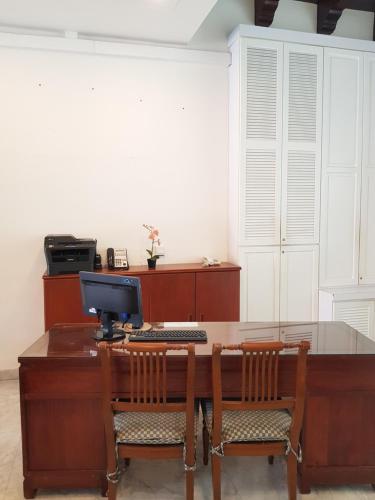 an office with a desk with a computer and two chairs at Heeren Straits Hotel in Melaka