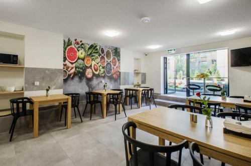 a restaurant with tables and chairs and a painting on the wall at Bema Rooms in Łódź