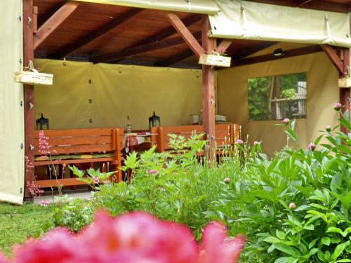 un patio con un banco, una mesa y flores en Illés Vendégház, en Keszthely