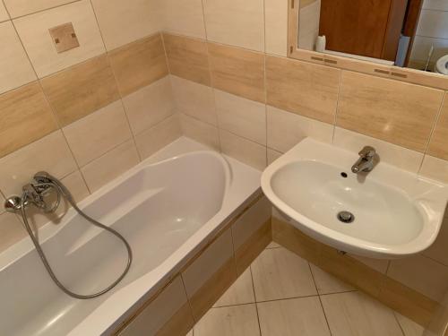 a bathroom with a sink and a bath tub at Jakócs szállása in Balatonfüred