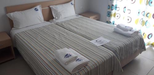 a hotel room with a bed with towels on it at TETYK Keramoti Hotel Apartments in Keramotí