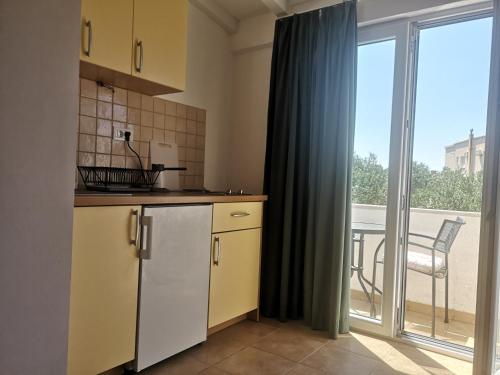 a small kitchen with a view of a balcony at Apartments Tri Palme in Baška Voda