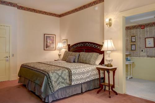 a bedroom with a bed and a table with two lamps at Mira Monte Inn & Suites in Bar Harbor