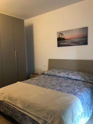 a bedroom with a bed and a painting on the wall at Un Balcone sul Garda in Tremosine Sul Garda