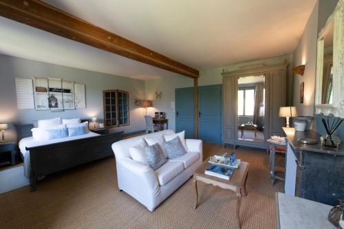 un salon avec un canapé blanc et une table dans l'établissement La Ferme de Bouchemont, à Saint-Symphorien